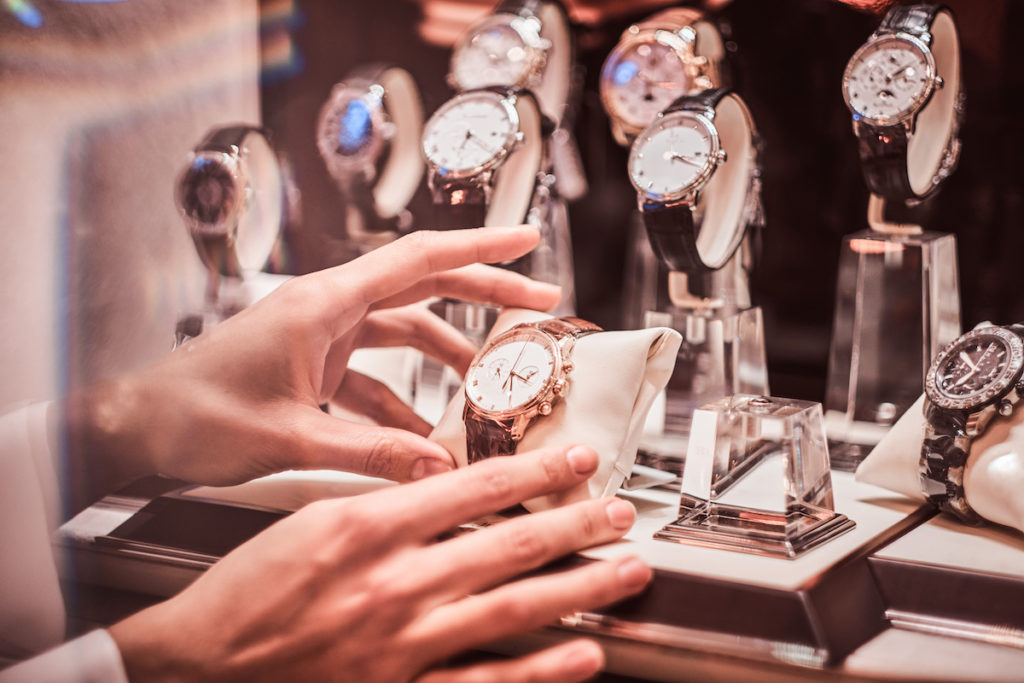 Close-up of the seller's hand shows the exclusive men's watch from the new collection in the luxury jewelry store